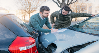 A driver gives his details to another man after a collision