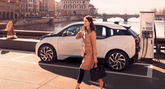 Business woman walks in front of charging BMW