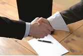 Handshake over desk confirming deal
