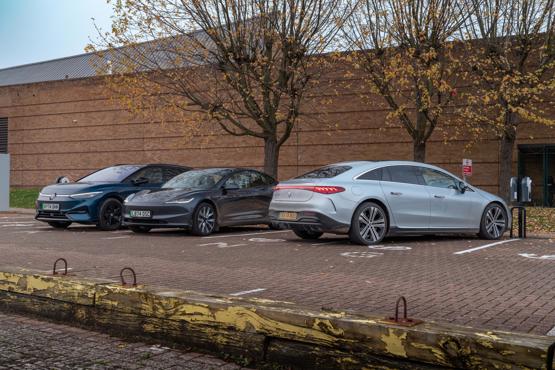 three electric cars parked by chargers