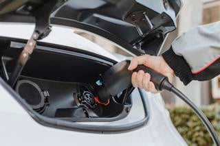 Electric van being plugged in to charge