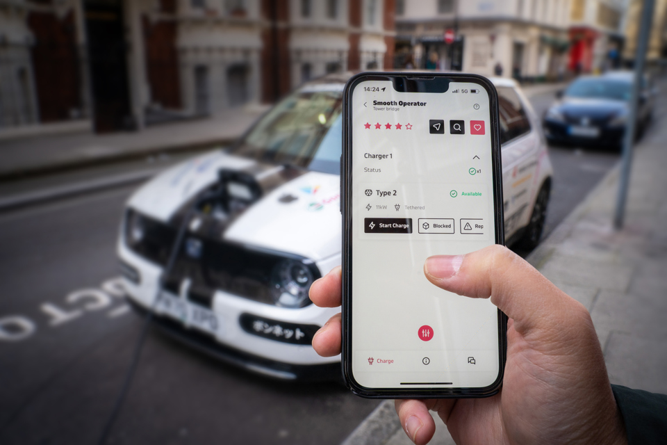 Person holding smartphone in front of Bonnet liveried EV