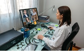 Woman sat at a desk having a video call on her computer