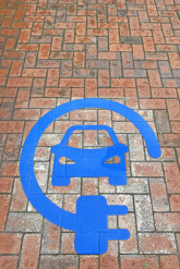 sign in blue on floor denoting parking space for electric vehicle charging