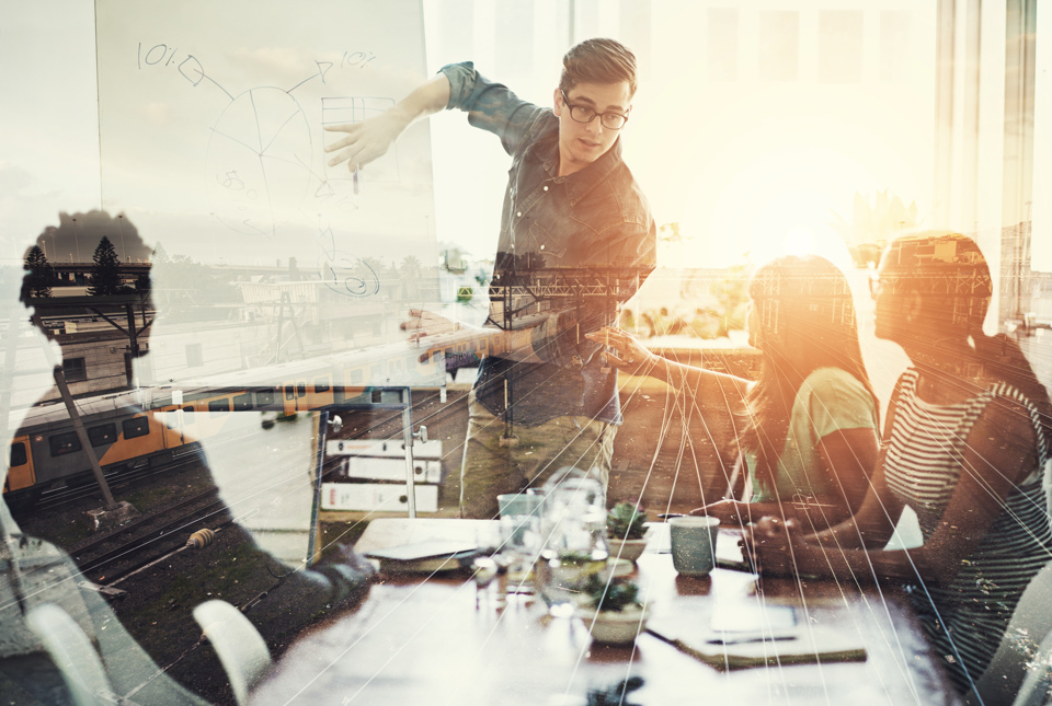 Man outlining plan on screen to colleagues