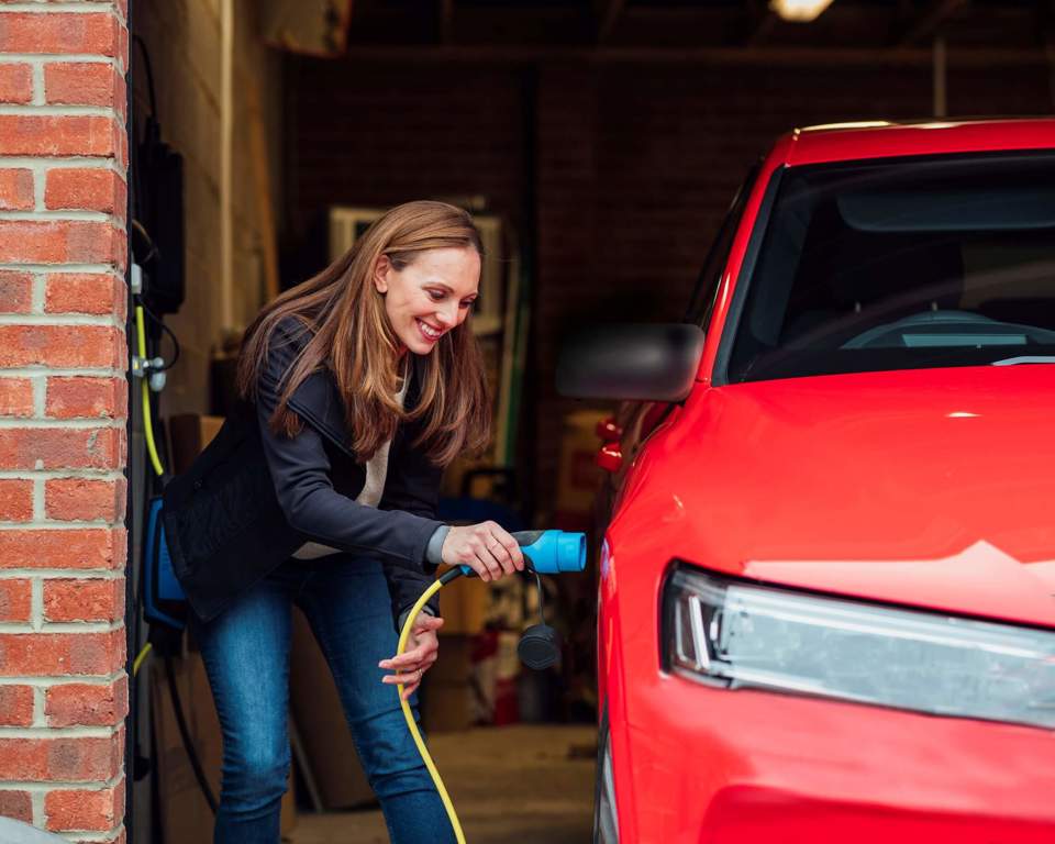 Person plugging in electric car charger