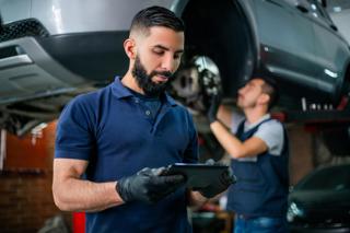 two mechanics working on car