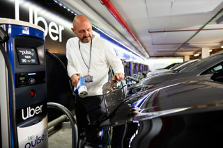 Uber driver plugging electric vehicle into charger 