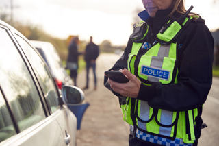 Police officer stood beside car