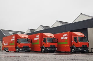 Three of the new Warburton electric trucks parked in a yard.