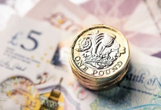 pounds coins on top of some bank notes