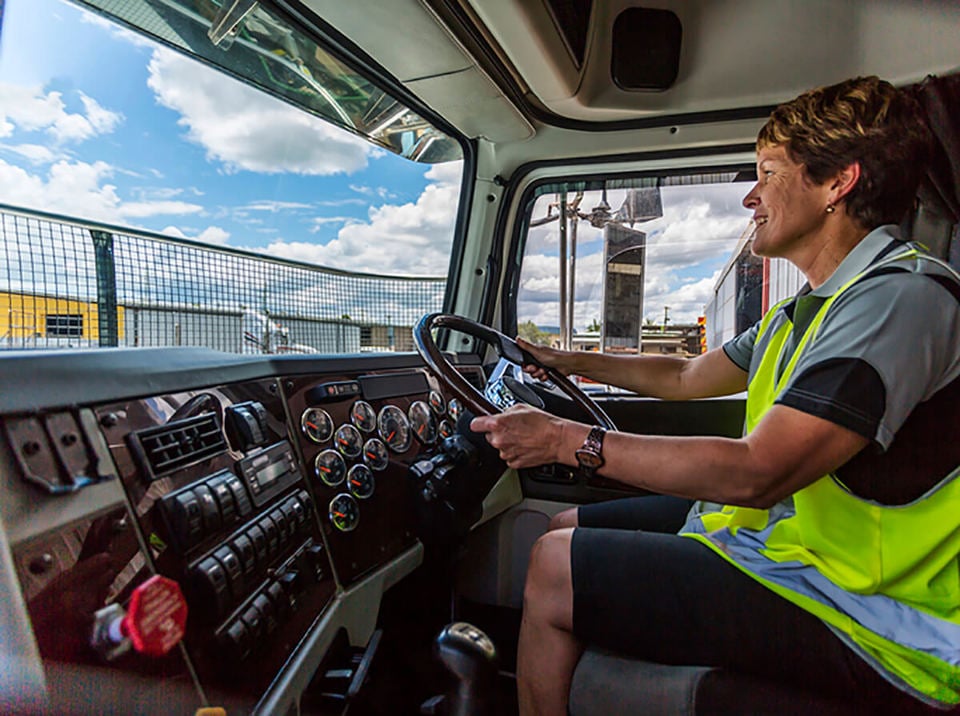 Lorry driver wearing a high-vis jacket in the cab