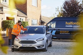 Halfords mobile expert technician looking at car on customer's drive